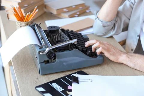 Male screenwriter using typewriter at table in office, closeup Stock Photos