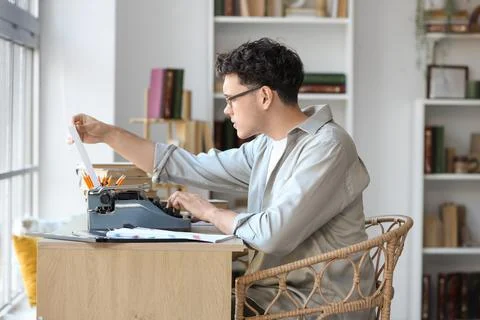 Male screenwriter using typewriter at table in office Stock Photos
