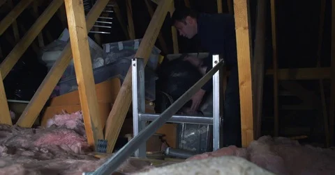 Male searching for some object stored away in his attic Stock Footage