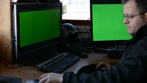 Male Security Guard On Workplace In Action. One monitor with chromakey 動画素材 99502299