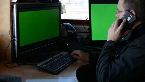 Male Security Guard On Workplace In Action. One monitor with chromakey 動画素材 99502520