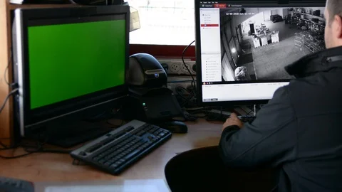 Male Security Guard On Workplace In Action. One monitor with chromakey Vídeos de archivo 99502593