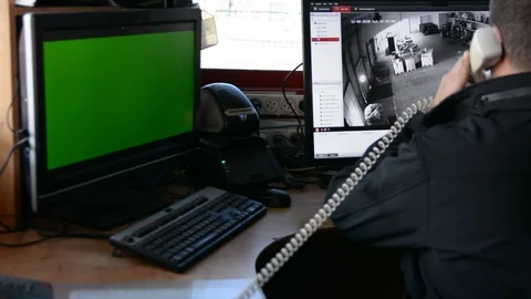 Male Security Guard On Workplace In Action. One monitor with chromakey 動画素材 99502821