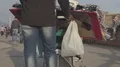 Male selling souvenirs for tourists in seaside city street, people strolling HD Footage