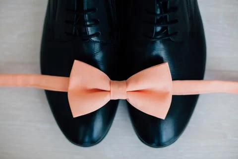 Male shoes and pink bow tie Stock Photos