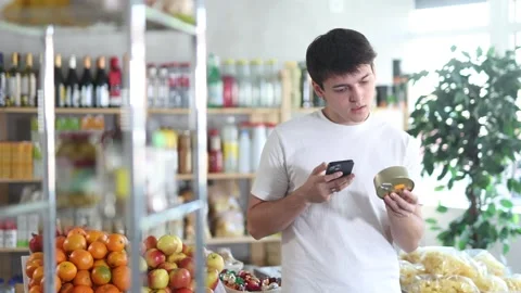 Male shopper scanning QR code on tin can label in grocery department of Stock Footage 321722802