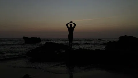 Male Silhouette Stretching While Waves Crash Sunset Sunrise Stock Footage 120131795
