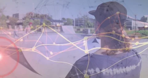 Male skater facing away from camera at outdoor skate park, showing technology Stock Footage 329782877