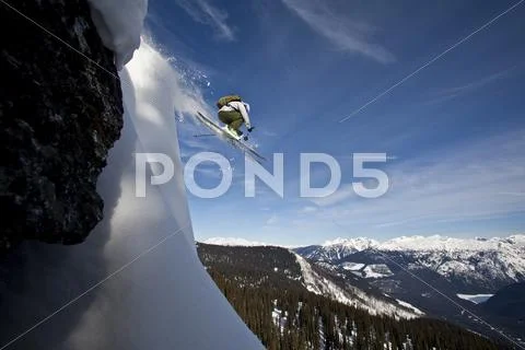 A Male Skier Airs Off A Snow Pillow While On A Cat Ski Trip. Monashee Mountains,