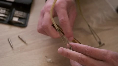 Male skilled hands working Close-up, eyeglass frames, emphasizing precision.. Video stock 289484026