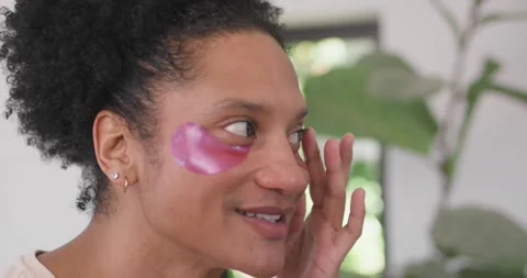 Male smiling, touching pink hydrogel eye patch, inspecting and smoothing Stock Footage 337288059