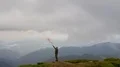 The male with the smoke bomb standing on the mountain top 4k or 4k+ Resolution