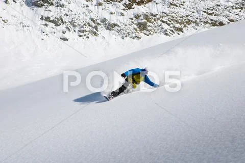 Male Snowboarder Snowboarding Down Steep Mountain, Trient, Swiss Alps,