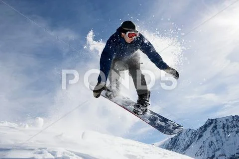 Male Snowboarding On Mountain