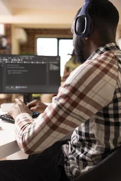 Male software developer with headphones coding from home Stock Photos