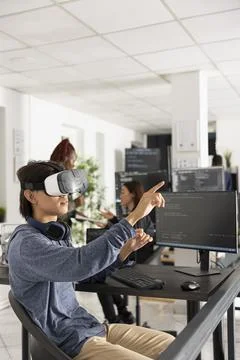 Male software developer raises arm to interact with 3D digital interface 스톡 사진
