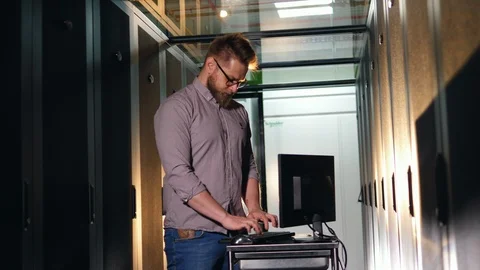 Male specialist is operating a computer in a server room Stock Footage 111289367