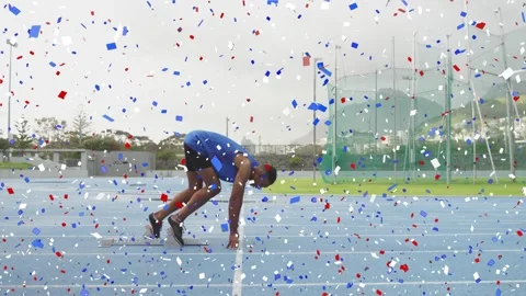 Male sprinter launching from blocks on start cue into sprint down blue track Stock Footage 329610083