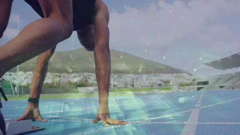Male sprinter pushing off starting blocks driving down sports track light Stock Footage 333425920