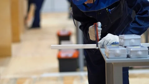 Male stand, cuts long rectangular rod, detail on workbench with hand hacksaw Stock Footage 126357746