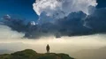 The male standing on a mountain against the cloud stream background. time lapse 4k or 4k+ Resolution