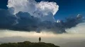 The male standing on a mountain on a cloud stream background. time lapse 4k or 4k+ Resolution