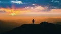 The male standing on the mountain top against a beautiful sunset 4k or 4k+ Resolution