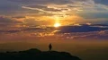 The male standing on a mountain top on a sunset background. time lapse 4k or 4k+ Resolution