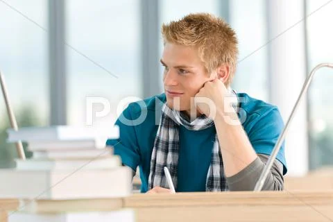 Male student with books sitting at table Stock Photos