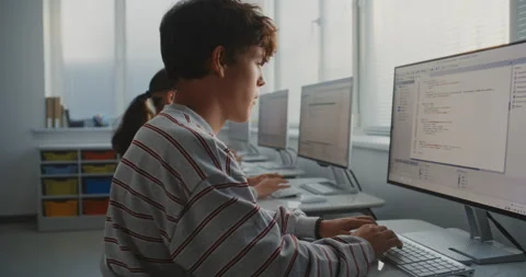 Male Student Learning Programming at Computer in Bright Classroom Stock Footage 318518534