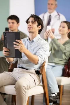 Male student scanning qr code in lecture hall Stock Photos