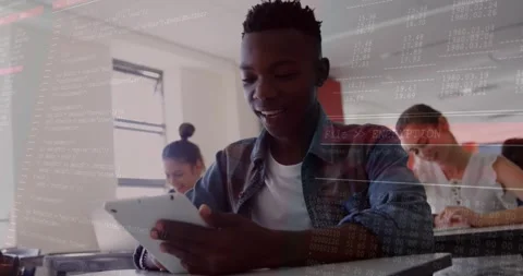 Male student tapping tablet showing encryption code while classmates writing Stock Footage 327064763