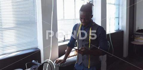 Male student using smartphone at a fashion college Stock Photos