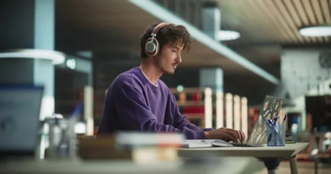 Male Studying on Laptop Computer in Library Stock Footage 256039104