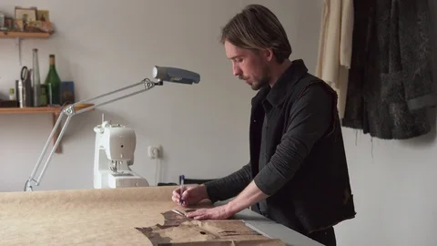 Male tailor creating clothing pattern while working at workplace Video stock 100617307