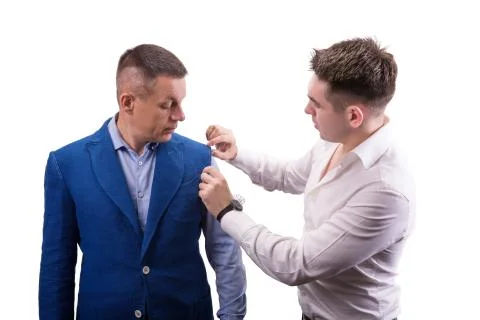 Male tailor designer make marks on a jacket during bespoke suit fitting Stock Photos