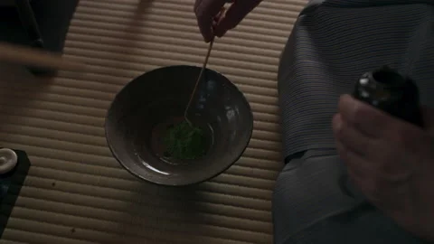 Male tea master adding powdered matcha tea to a bowl in a traditional Japanese h Video stock 199456792
