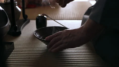 Male tea master using a bamboo matcha tea whisk to whisk the powder with hot wat Stock Footage 199460120