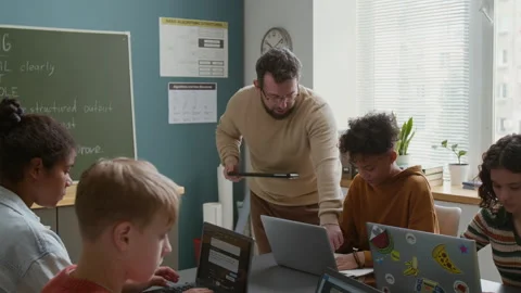 Male Teacher Checking on Students Writing Prompts for AI Generator Stock Footage 318719655
