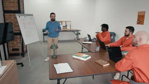 Male Teacher Conducting Computer Programming Lesson for Diverse Convicts Stock Footage 314056557