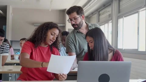 Male teacher explaining in class to a group of diverse students Stock Footage 202165137