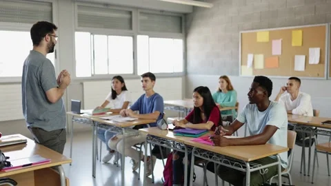 Male teacher explaining lesson to high school students in classroom. Stock Footage 221851004