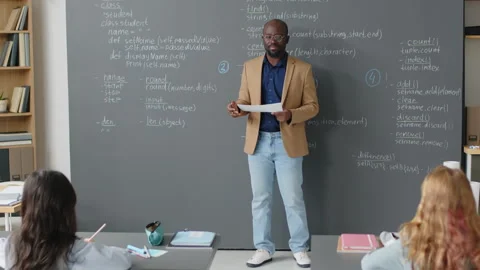 Male Teacher Explaining Material in front of Board Stock Footage 244695004
