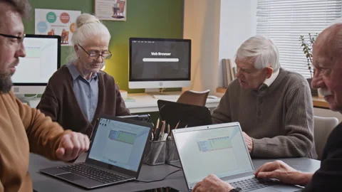 Male Teacher Explaining Tasks to Senior Man in Computer Literacy Class Stock Footage 333705703