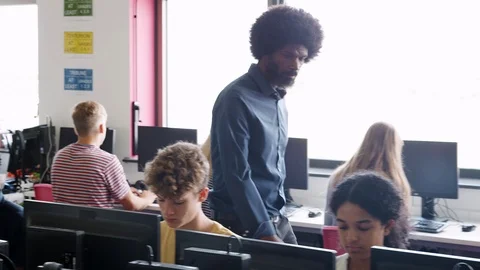 Male Teacher Helping Teenage Female High School Student Working In Computer Stock Footage