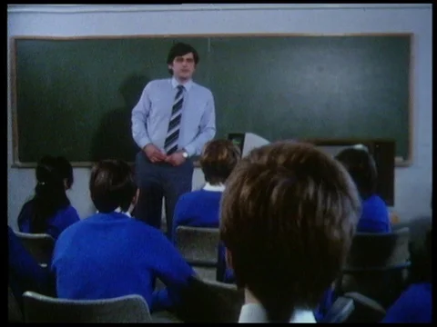 Male teacher introducing new computer to students sitting in class, 1985 Stock Footage 136676255
