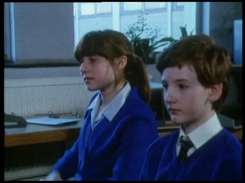 Male teacher introducing new computer to students sitting in class, 1985 Stock Footage 136676332