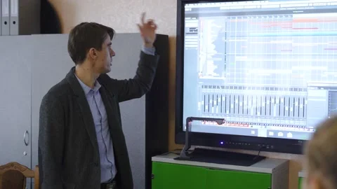 Male teacher using an interactive whiteboard in an empty classroom teaching Stock Footage 212098676