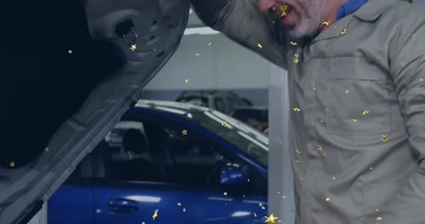 Male tech checking engine bay in auto shop, closing hood after check, smiling Stock Footage 329946410