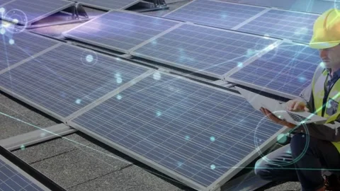 Male tech entering frame, kneeling by roof solar panels, monitoring diagnostics Stock Footage 331736641